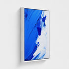 Abstract art print with blue and white strokes in a white frame on a light gray background