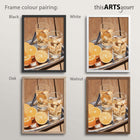 Artwork of oranges and drinks glasses on a tray in black, white, oak and walnut frames.
