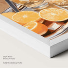 Artwork of oranges and drinks glasses on a tray in a chalk wood frame.