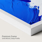 Blue abstract painting with a chalk wood frame on a plain background