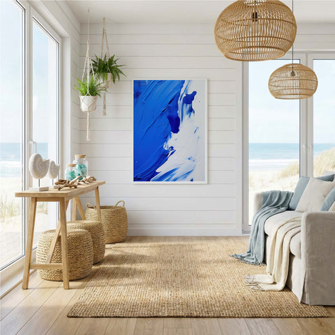 Modern living room with abstract blue art print, natural light, and coastal decor.