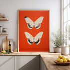 Butterfly art print on an red background in a modern kitchen.