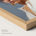 Artwork of a woman placed within a natural wood frame.