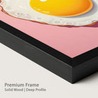 Framed artwork of a fried egg on a pink background with a onyx wood frame.