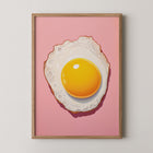 Framed art print of a fried egg on a pink background