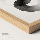 Natural wood frame with monochrome abstract artwork.